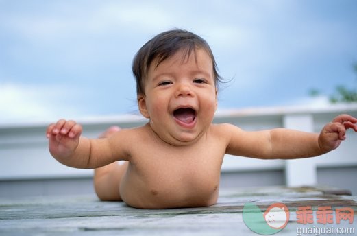 CD图片健康和美容,桌子,户外,裸体,躺_10012038_Baby (9-12 months) lying on stomach, laughing_创意图片_Getty Images China