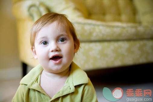 人,沙发,人的脸部,人的牙齿,快乐_128262743_Happy baby, 1 year old, in front of green couch_创意图片_Getty Images China