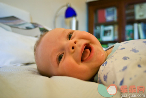 人,家具,住宅内部,床,室内_88768039_A joyous six month old infant displays a toothless smile._创意图片_Getty Images China