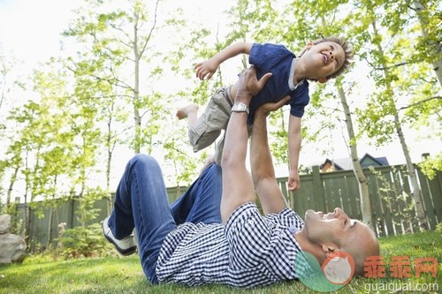 35岁到39岁,非裔美国人,高举手臂,后院,写实_gic14874500_Father lifting son while lying on grass outdoors._创意图片_Getty Images China