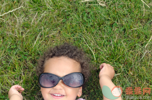人,户外,人的头部,人的脸部,太阳镜_157383566_Child wearing sunglasses lying on grass having fun_创意图片_Getty Images China