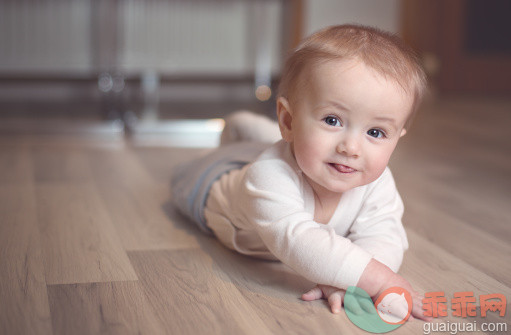 人,婴儿服装,室内,人的嘴,灰色眼睛_163493544_Cute baby smiling and commando crawling_创意图片_Getty Images China