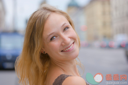 人,休闲装,运输,户外,20到24岁_155786814_Germany, Bavaria, Munich, Young woman smiling in front of Bavarian State Library at Ludwigstrasse_创意图片_Getty Images China