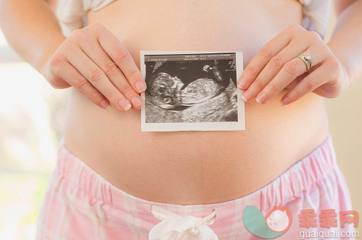 人,人生大事,生活方式,技术,室内_565881099_Caucasian woman holding sonogram over pregnant belly_创意图片_Getty Images China