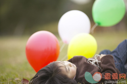 气球,串,白昼,白日梦,闭着眼睛_gic7229893_Young girl lying on the grass and day dreaming while holding balloons_创意图片_Getty Images China