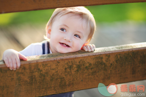 人,婴儿服装,户外,褐色眼睛,金色头发_170815852_Cute smiling Baby leaning on Handrail_创意图片_Getty Images China