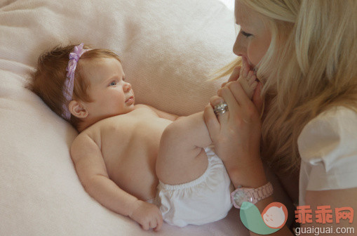 人,室内,25岁到29岁,金色头发,白人_133467452_Baby girl with mother kissing her toes_创意图片_Getty Images China