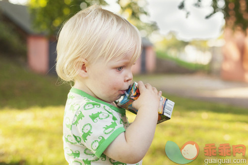 人,婴儿服装,饮料,户外,金色头发_gic18570398_Side view of cute baby boy drinking from juice box at park_创意图片_Getty Images China