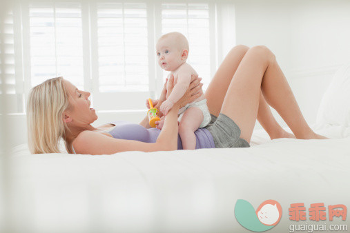 进行中,人,床,尿布,短裤_148198452_Mother playing with baby on bed_创意图片_Getty Images China