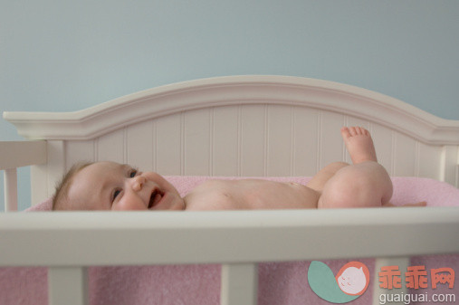 摄影,婴儿用品,婴儿床,可爱的,室内_200391533-001_Infant baby girl (6 months old) lying in crib, laughing_创意图片_Getty Images China