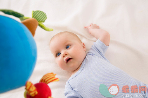 人,婴儿服装,床,玩具,2到5个月_155786778_Baby girl looking at toy, smiling_创意图片_Getty Images China