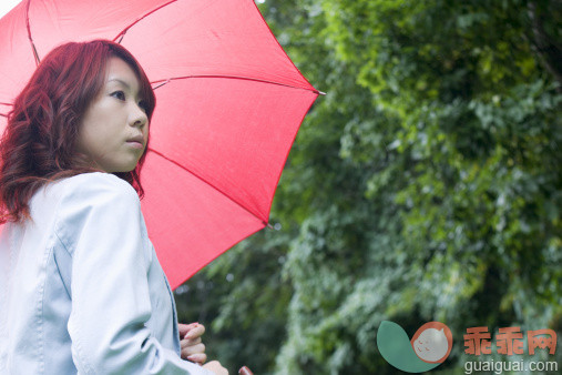公园,绿色,人,衣服,用具_122691055_Young woman holding an umbrella_创意图片_Getty Images China