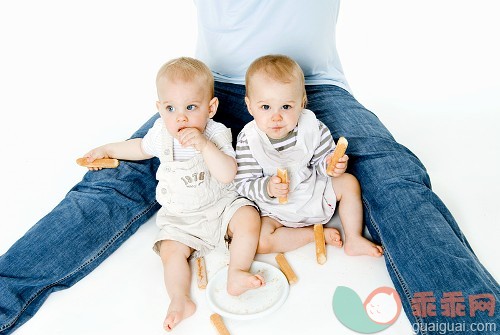 赤脚,衣服,吃,手指饼干,坐_gic7623825_Twin babies with sponge fingers_创意图片_Getty Images China