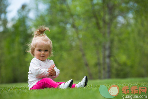 人,婴儿服装,户外,头发,金色头发_169786693_Infant girl sits in yard and looks at viewer_创意图片_Getty Images China