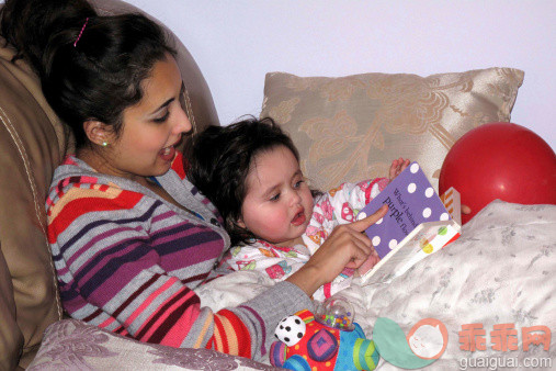 人,休闲装,气球,床,软垫_160949358_Mother reading book to baby girl lying on bed_创意图片_Getty Images China