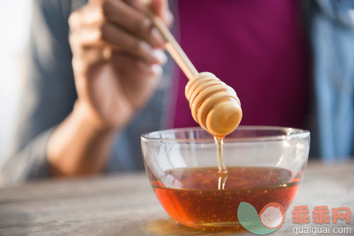 人,饮食,室内,中间部分,20到24岁_503847841_Mixed race woman holding honey dipper_创意图片_Getty Images China