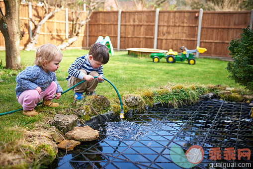 人,休闲装,户外,短发,金色头发_560039781_Two small children filling up a pond with a hoes_创意图片_Getty Images China