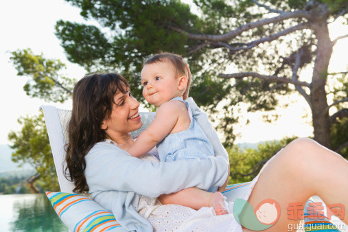 人,椅子,2到5个月,四分之三身长,户外_78937440_Woman holding a baby by an infinity pool smiling._创意图片_Getty Images China