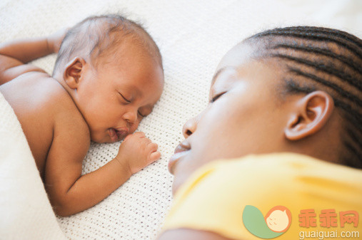 人,床,室内,25岁到29岁,卧室_139141530_Over the shoulder view of mother sleeping on bed facing her sleeping newborn baby in Johannesburg, South Africa_创意图片_Getty Images China