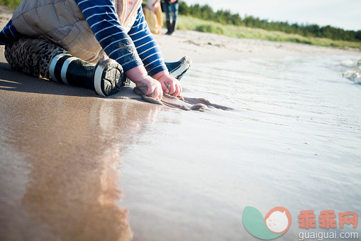 人,寒冷,度假,户外,腰部以下_562601425_Child playing on beach_创意图片_Getty Images China