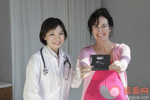 25岁到29岁,40到44岁,亚洲人,休闲装,白人_gic5420106_Female doctor with pregnant woman holding sonogram_创意图片_Getty Images China