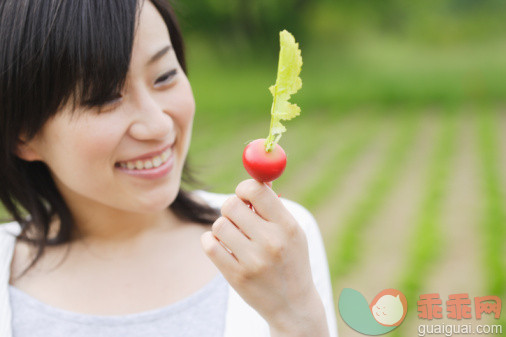 人,衣服,食品,度假,户外_83666141_Young smiling woman holding radish_创意图片_Getty Images China