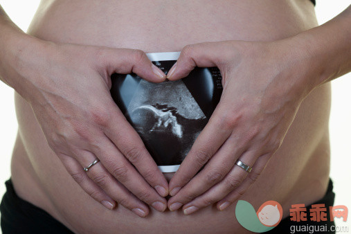 人,休闲装,半装,人生大事,生活方式_145065050_A pregnant woman holding an ultrasound printout against her belly_创意图片_Getty Images China