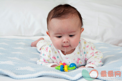 水滴,人,床,连身衣,2到5个月_145062981_Baby girl lying on front on blue blanket on bed drooling looking at teething ring_创意图片_Getty Images China