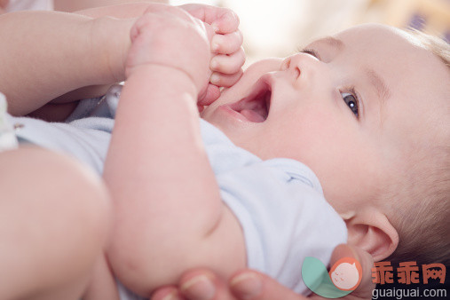 人,婴儿服装,室内,人的脸部,手_163497355_Baby trying to put foot in his mouth_创意图片_Getty Images China