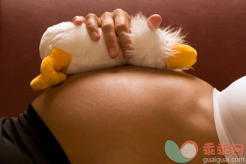 概念,健康保健,人类生殖,主题,人生大事_73264345_Pregnant woman lying, soft toy on belly, mid-section, close-up_创意图片_Getty Images China