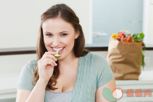 人,饮食,休闲装,包,室内_112230326_Germany, Cologne, Young woman eating cucumber slice, smiling, portrait_创意图片_Getty Images China