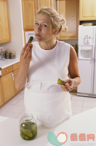 厨房,人,衣服,饮食,事件_gic17185663_Portrait of a pregnant woman eating pickles_创意图片_Getty Images China