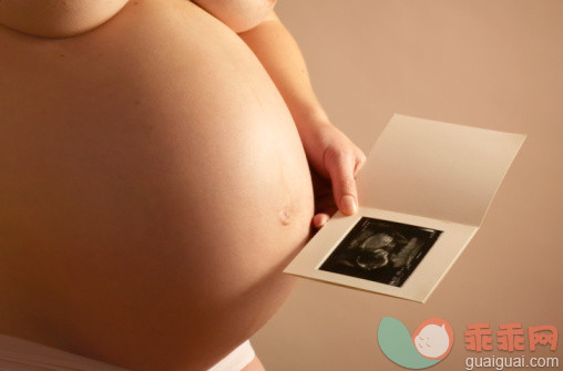 人,半装,影棚拍摄,中间部分,35岁到39岁_sb10067654d-001_Pregnant woman holding baby scan photo next to belly, close up, mid section_创意图片_Getty Images China