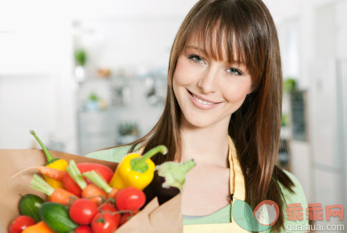 人,饮食,休闲装,室内,住宅房间_116376427_Germany, Cologne, Woman standing in kitchen with vegetables bag_创意图片_Getty Images China