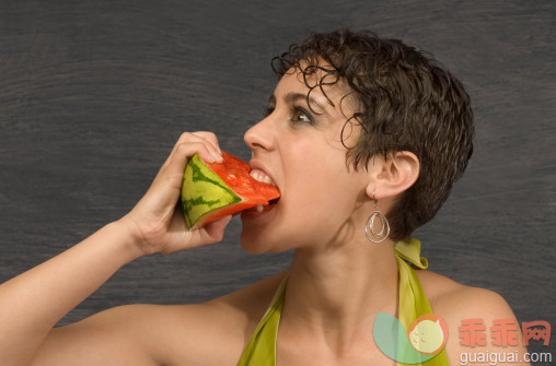 人,影棚拍摄,室内,拿着,吃_88791271_Young woman eating watermelon_创意图片_Getty Images China