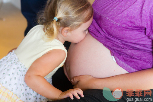 人,室内,中间部分,25岁到29岁,深情的_509673105_A small girl kissing pregnant woman's bare belly_创意图片_Getty Images China