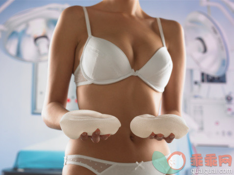 健康保健,健康生活方式,身体关注,摄影,室内_200391793-001_Young woman in underwear, holding breast implants, mid section_创意图片_Getty Images China