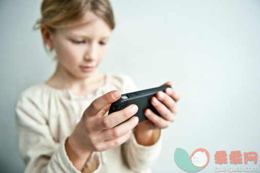 人,沟通,影棚拍摄,长发,金色头发_145049474_young girl plays with a cell phone_创意图片_Getty Images China