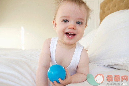 人,床,玩具,室内,蓝色眼睛_477355283_Portrait of a very happy baby holding a ball_创意图片_Getty Images China