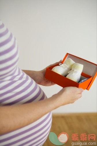 人,休闲装,礼物,盒子,室内_73246086_Pregnant woman holding booties, mid section, close-up_创意图片_Getty Images China