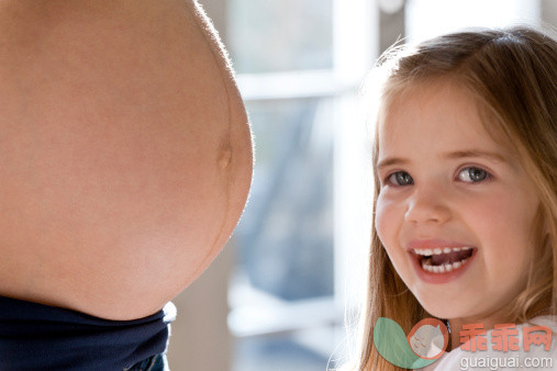 人,休闲装,人生大事,生活方式,室内_160689552_Portrait of girl smiling next to pregnant mother's belly_创意图片_Getty Images China