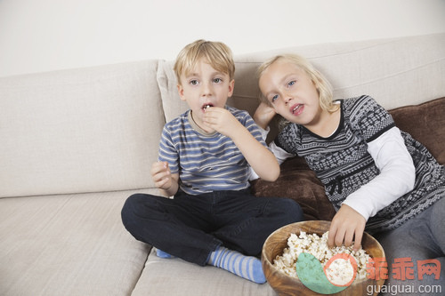 人,休闲装,住宅内部,沙发,生活方式_gic18696926_Brother and sister watching TV and eating popcorn_创意图片_Getty Images China