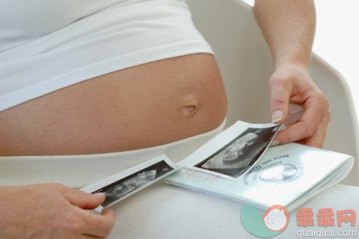 技术,健康保健,人类生殖,概念,主题_73264196_Pregnant woman looking at ultrasound images of baby, close-up_创意图片_Getty Images China