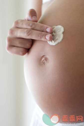 人,室内,中间部分,25岁到29岁,手_137082418_Woman applying moisturizer to pregnant belly, cropped_创意图片_Getty Images China