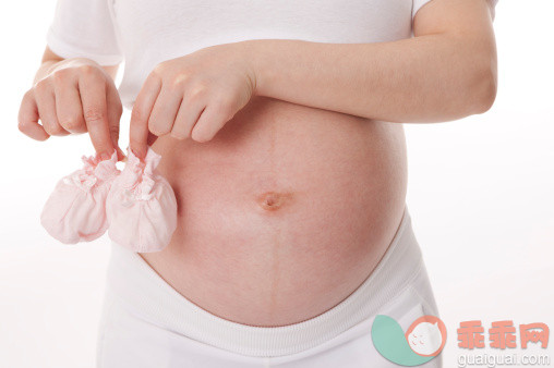 人,影棚拍摄,室内,中间部分,30岁到34岁_159283283_Pregnant woman holding baby booties_创意图片_Getty Images China