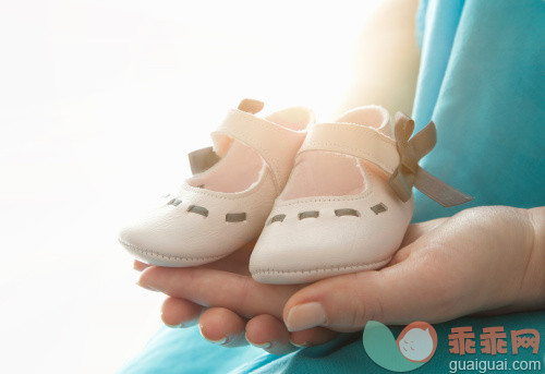 人,休闲装,室内,中间部分,30岁到34岁_139116827_Woman's hands with baby shoes_创意图片_Getty Images China