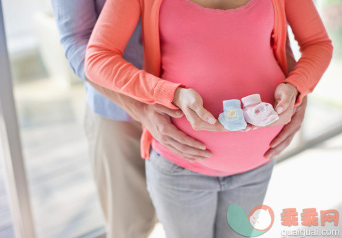 人,休闲装,人生大事,生活方式,室内_135385237_Pregnant woman holding baby booties_创意图片_Getty Images China