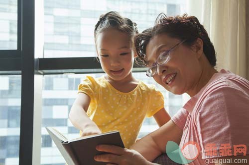 休闲装,沙发,软垫,室内,60到64岁_gic8230239_Grandmother reading book to her granddaughter_创意图片_Getty Images China