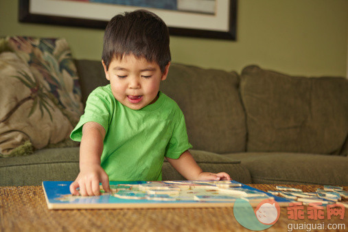 写,人,住宅内部,沙发,软垫_480984427_Boy playing puzzle in living room_创意图片_Getty Images China