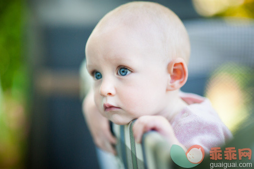 人,婴儿服装,户外,蓝色眼睛,白人_494605767_Infant baby girl looking wistful in playpen_创意图片_Getty Images China